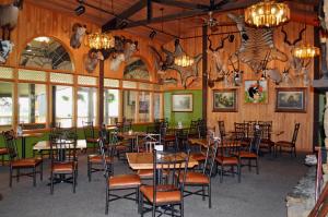 Hot Springs Hotel & Spa في ثرموبوليس: مطعم بجدران خشبية وطاولات وكراسي