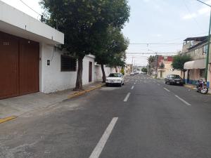 an empty street with cars parked on the side of the road at Apartamento Centricovive El Pulsar De La Ciudad in Toluca