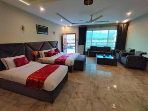 a hotel room with two beds and a couch at Swat Hilton Hotel by Khan Familia in Swat