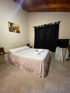 Un dormitorio con una cama con sábanas blancas y flores. en Lo de Mora, en Cafayate