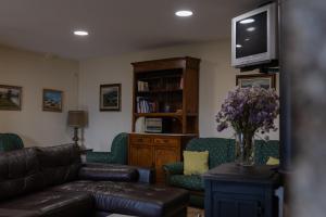 a living room with a couch and chairs and a tv at Casa A Chairiña y A Revolta in Arnoia