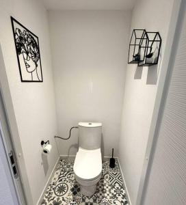 uma casa de banho com WC e piso em azulejo preto e branco em * Nouveauté* Gîte le Lamala em Bennwihr
