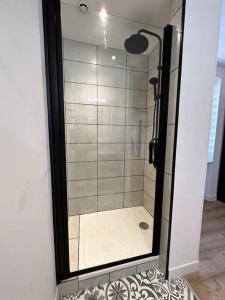 um chuveiro com uma porta de vidro na casa de banho em * Nouveauté* Gîte le Lamala em Bennwihr