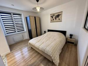 um quarto com uma cama e piso em madeira em * Nouveauté* Gîte le Lamala em Bennwihr