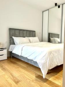 een slaapkamer met een groot bed en een houten vloer bij Bulevard17 in Belgrado