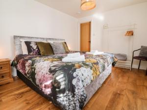 a bedroom with a large bed with a colorful bedspread at Cosy Cottage in Lifton