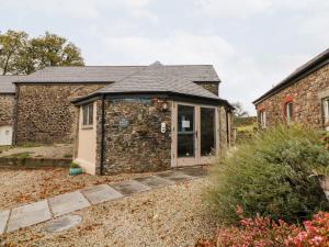 an old stone building with a door in front of it at Cosy Cottage in Lifton