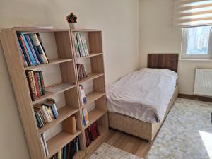 um quarto com uma cama e uma estante de livros com livros em University residences em Avcılar