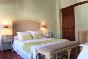 een slaapkamer met een bed met 2 lampen en een stoel bij Casa Rural El Gaiter in Aguaviva