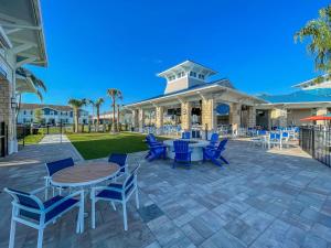 a patio with blue chairs and tables and a building at Star Wars Moana Princess Mario Avatar Near Disney in Davenport