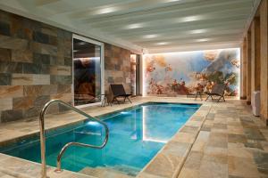 - une piscine dans une pièce ornée d'une peinture murale dans l'établissement Best Western Premier Hotel des Vignes et des Anges, à Pauillac