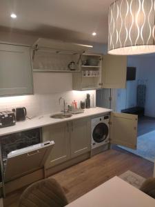 a kitchen with a sink and a washing machine at Exquisite Long-Term Living in Cardiff's Heart in Cardiff