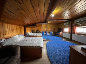 a bedroom with two beds and a blue rug at Vila 8 oaspeti in Bucharest