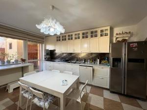 a kitchen with a white table and a refrigerator at Vila 8 oaspeti in Bucharest