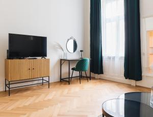 a living room with a television and a chair at Brand Cozy Apartment in Vienna