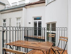 y balcón con mesa y sillas de madera. en Brand Cozy Apartment en Viena