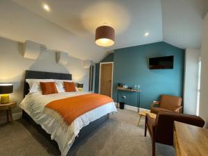 a bedroom with a bed and a table and a chair at Allium in Tenby