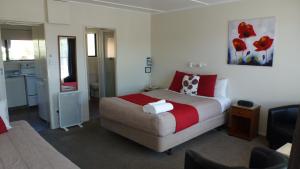 a hotel room with a bed and a kitchen at ASURE Adcroft Motel in Ashburton