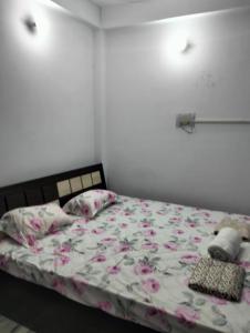 um quarto com uma cama com flores cor-de-rosa em Darbar Homestay em Gaya