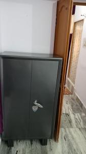 une armoire noire avec une poignée d'argent dans une pièce dans l'établissement Darbar Homestay, à Gaya