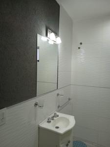 W białej łazience znajduje się umywalka i lustro. w obiekcie A mi manera - Casa de Sierra w mieście Villa Giardino