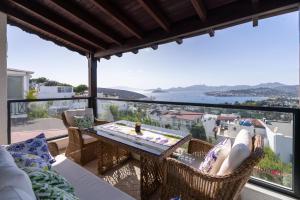 a patio with a table and chairs on a balcony at Villa Bitez in Bodrum City