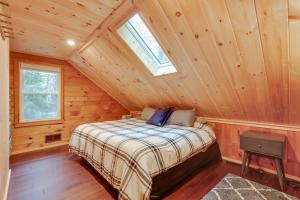 1 dormitorio con 1 cama en una cabaña de madera en Waterfront Newbury Retreat with Grill and Dock!, en Newbury