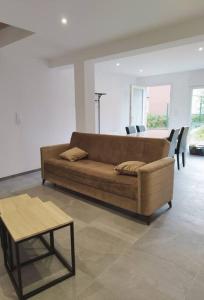 a living room with a brown couch and a table at Gîtel'harmonie2 in Fraize