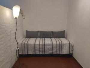 een klein bed in een kamer met een lamp bij DEPARTAMENTO LA ESTACION in Tigre