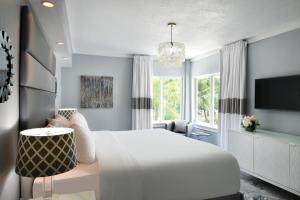 a bedroom with a white bed and a tv at Beacon South Beach Hotel in Miami Beach