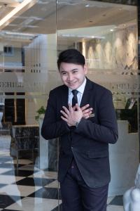 a young man in a suit and tie posing for a picture at Stonehill Suites in Bacolod