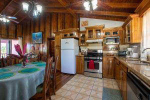 uma cozinha com uma mesa e um frigorífico branco em Miramar Suites em Placencia Village