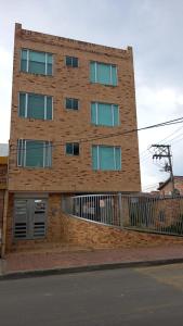 a tall brick building with a fence in front of it at Espectacular apartamento con estacionamiento gratuito Chía N 2 in Chía
