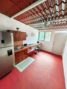 uma cozinha com piso vermelho e um frigorífico em Casa Olivo, tranquilidad y descanso. em Mérida