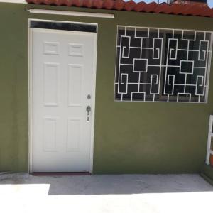 uma porta branca numa parede verde com uma imagem em Casa Olivo, tranquilidad y descanso. em Mérida