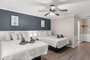 um quarto com 2 camas e uma ventoinha de tecto em Dry Dock Inn em Carolina Beach