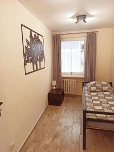 a small bedroom with a bed and a window at APARTAMENT CENTRUM Międzychód in Międzychód