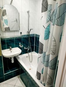 a bathroom with a sink and a tub and a shower at APARTAMENT CENTRUM Międzychód in Międzychód