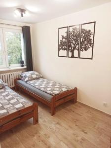 1 dormitorio con 2 camas y una foto de árbol en la pared en APARTAMENT CENTRUM Międzychód en Międzychód