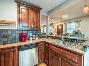 a kitchen with wooden cabinets and a stainless steel dishwasher at Quiet Plaza Two bedroom 2 Bathroom in Kansas City +26 photos