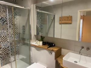 a bathroom with a glass shower and a sink at Brixton hill apartments in London