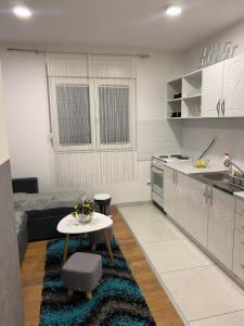 uma cozinha com uma pequena mesa e uma cozinha com uma cama em Apartman Sara 2 em Novi Grad