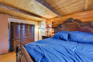 a bedroom with a blue bed with a wooden ceiling at Philipsburg Log Cabin - Direct Bike Park Access! in Georgetown