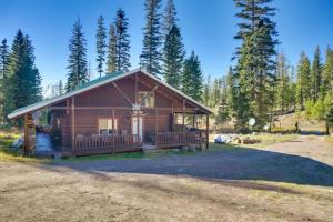 a log cabin with a porch in the woods at Philipsburg Log Cabin - Direct Ski Lift Access! in Georgetown