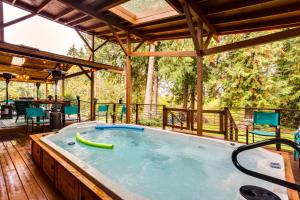 a hot tub on a deck with a patio with chairs at Peaceful Renton Retreat with Hot Tub Access! in Renton