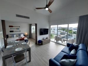 a living room with a blue couch and a bed at Seaside Luxury 1BDR Condo Paseo Playa Coral D-306 in Punta Cana