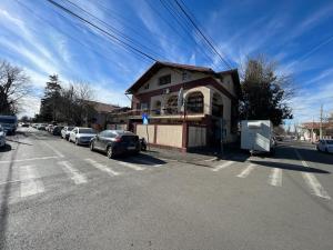 a house with cars parked on the side of a street at Vila 8 oaspeti in Bucharest