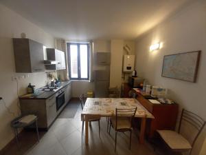 een kleine keuken met een tafel en een tafel en stoelen bij Console Camprini Rooms & Apartments in Faenza