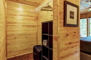 uma cabina de madeira com painéis de madeira em Waterside Cottage by Sarah Bernard with Firepit, Private Dock, and Hot Tub em Innsbrook