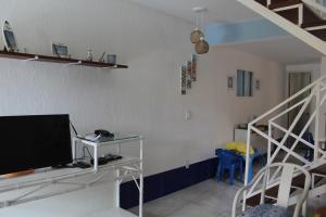 a living room with a tv and a staircase at Casa em Búzios com Vista para o Mar in Búzios